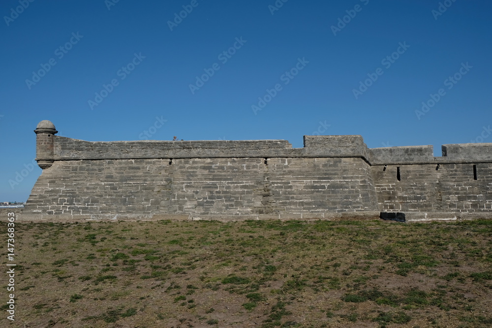 Side view of Castillo de San Marcos in St Augustine, Florida, USA. Oldest fortress in America built in 1672 in Matanzas Bay Florida. Blue skies no clouds. Historic landmark.