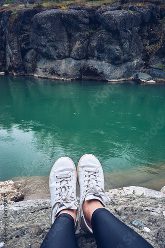 Girls feet on river background