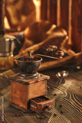 Coffee grinder of roasted coffee on wooden table.