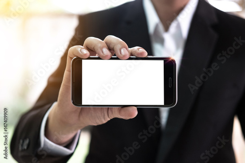 Close up of a business man using smartphone with blank screen mobile.