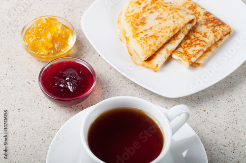 Cup of tea with jam, sour cream and russian pancakes - blini