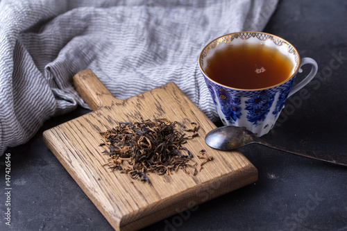 Porcelain cup of black tea on a dark background. Hot drink - black tea photo