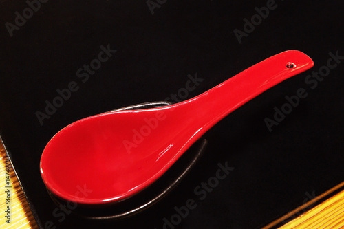 Japanese red spoon over black tray usually used to eat traditional soup 