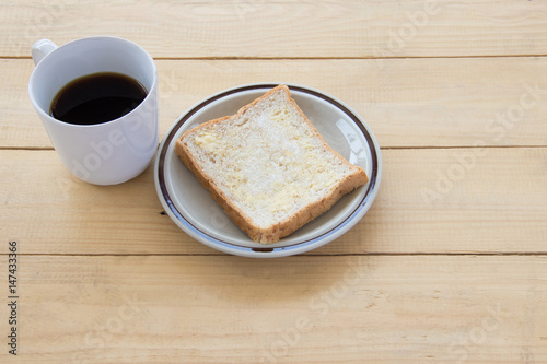 Black coffee and bread on wooden of brown photo