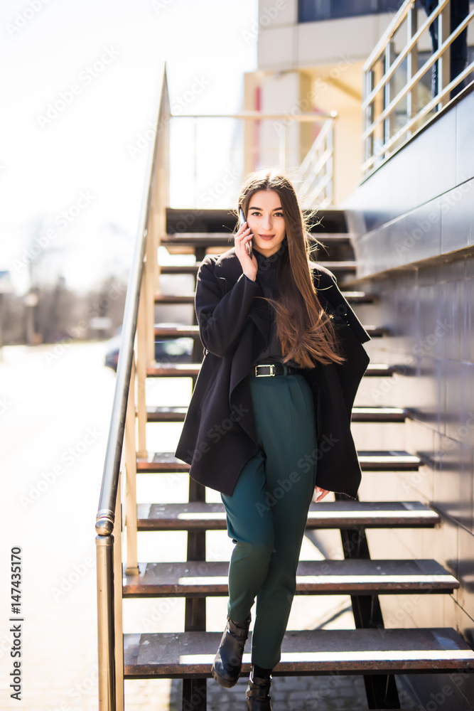 Young businesswoman on the stairs using the phone Young businesswoman on the stairs using the phone