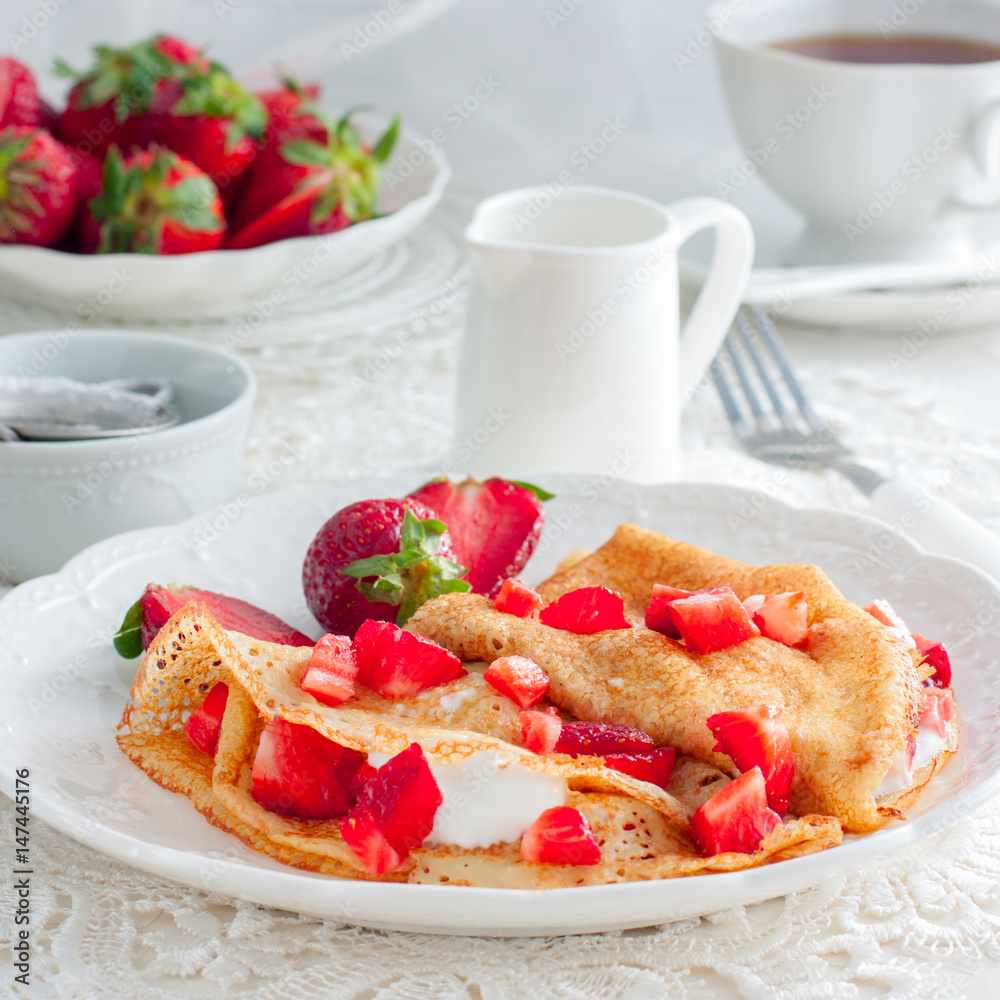Thin pancakes with strawberries and sour cream, square Thin pancakes with strawberries and sour cream, square