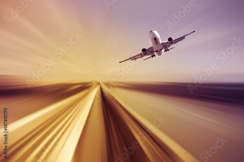 Airliner over highway on blurred background © JackF