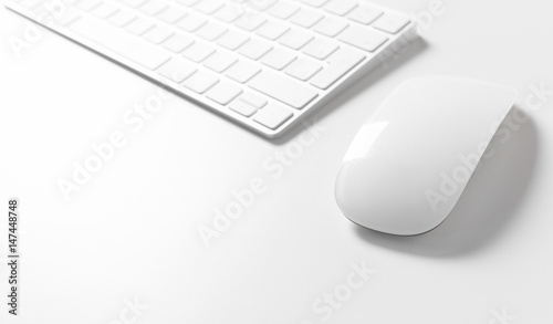 Computer keyboard and mouse on top of white desktop