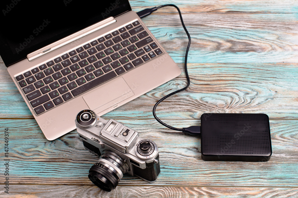 The tablet and camera lying on wooden blue background The tablet and camera lying on wooden blue background