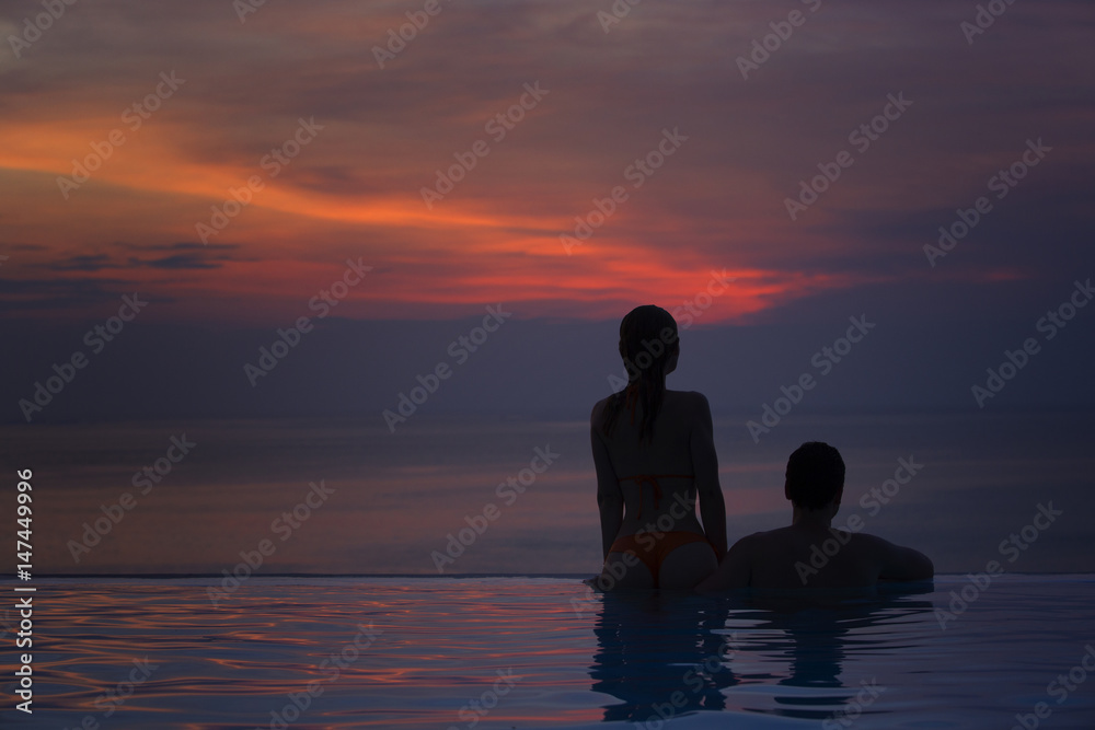 Man and woman at sunset by the sea.