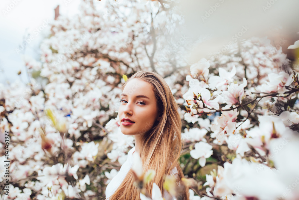 portrait of young woman surrounded with magnolia tree portrait of young woman surrounded with magnolia tree