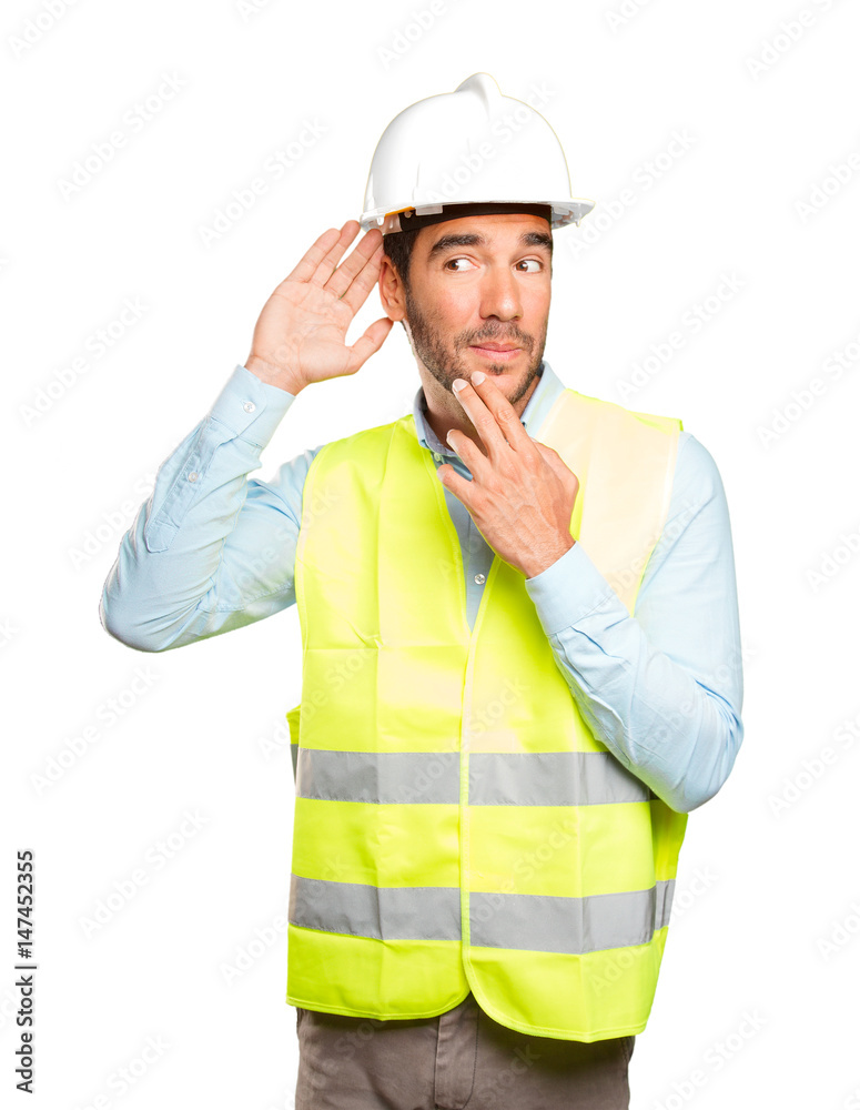 Surprised engineer trying to listen against white background