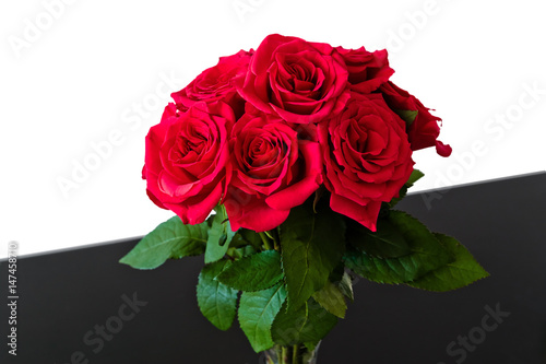 Bouquet of red roses on black surface and with white background