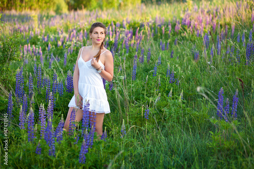молодая красивая девушка в цветочном поле из люпинов