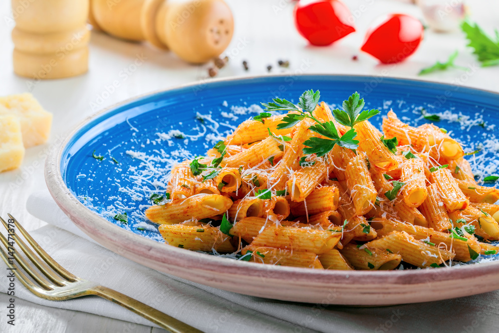 Φωτογραφία Traditional penne pasta with hot arrabiata tomato sauce and parsley on a white wooden table