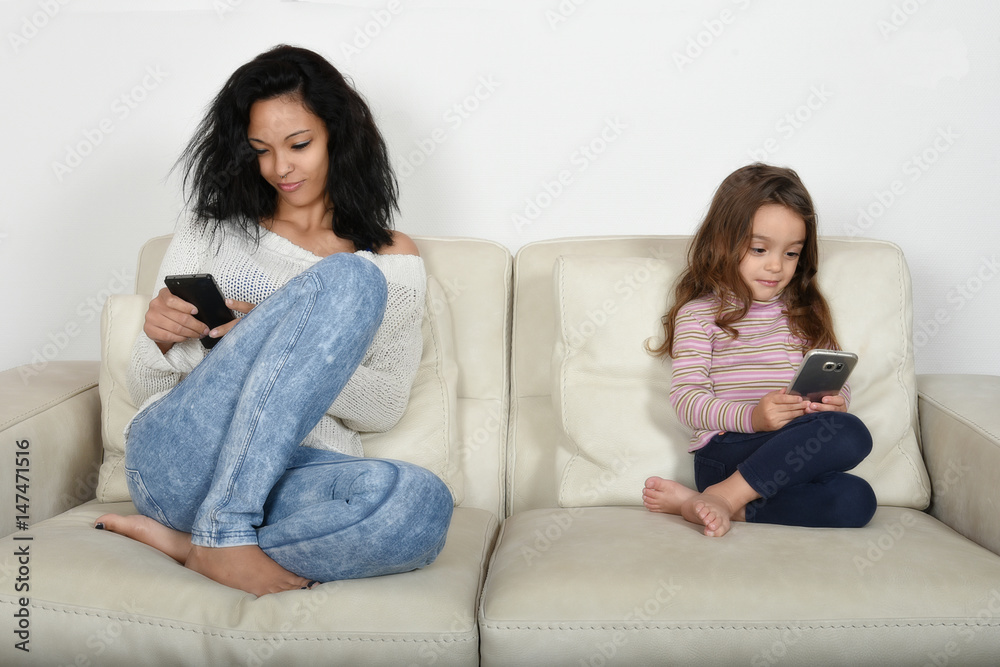 jeune mère et sa fille jouant avec leur téléphone