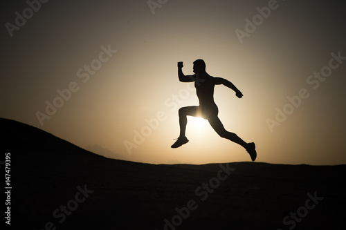 man running silhouette at sunset  young caucasian run in mountain
