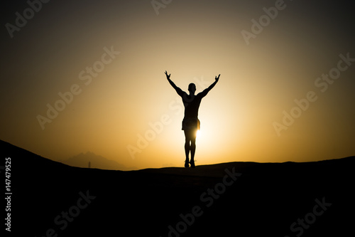 muscular man silhouette at sunset sky