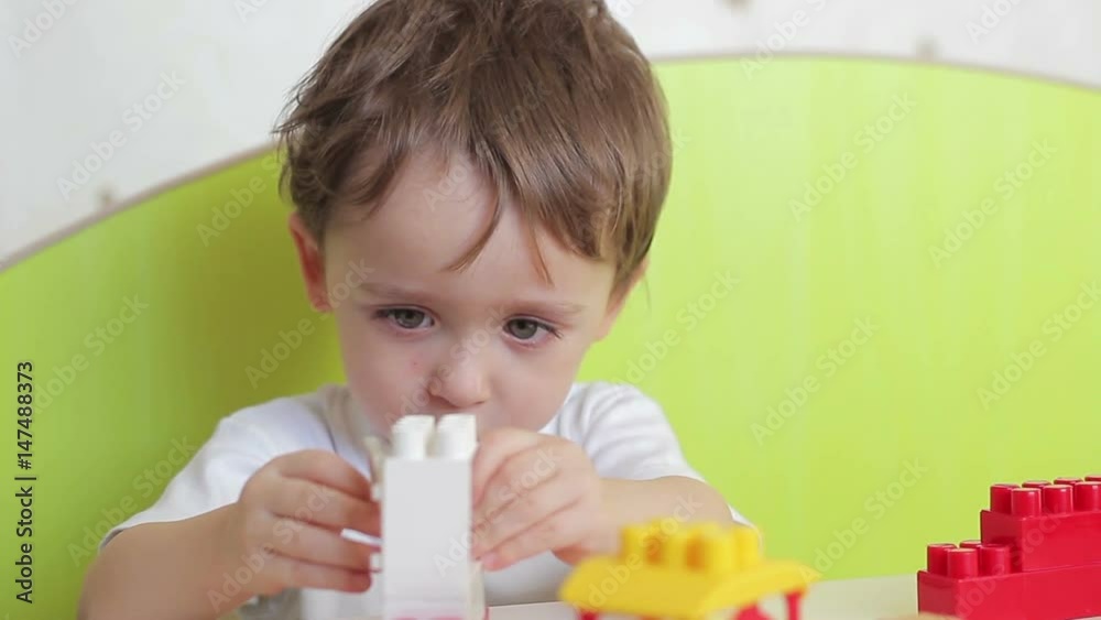 Boy child playing with colored blocks on the table Boy child playing with colored blocks on the table