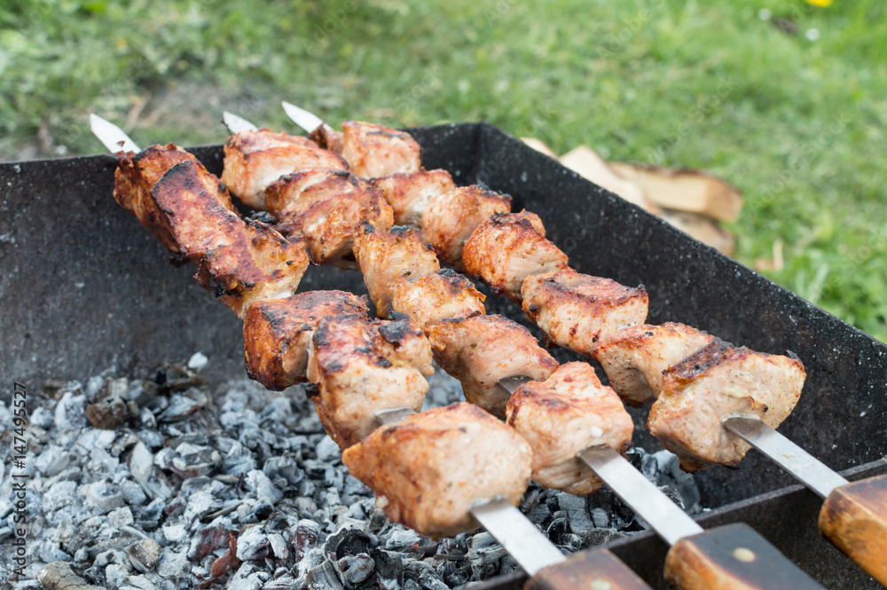 juicy fried meat on skewers outdoors
