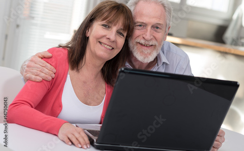 Happy mature couple using laptop © thodonal