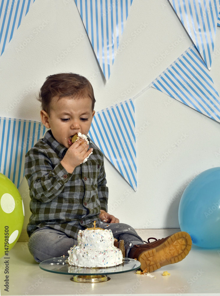 niño comiendo el pastel de su cumpleaños. Stock Photo | Adobe Stock