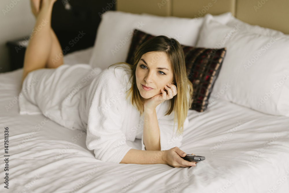 beautiful woman lying in bed and watch tv in hotel room beautiful woman lying in bed and watch tv in hotel room