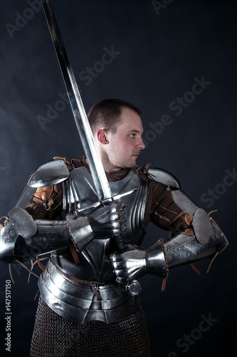 A medieval warrior with a sword. Knight on dark background