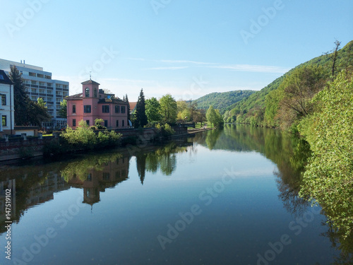 Riverside with reflections of the scenery on calm water surface