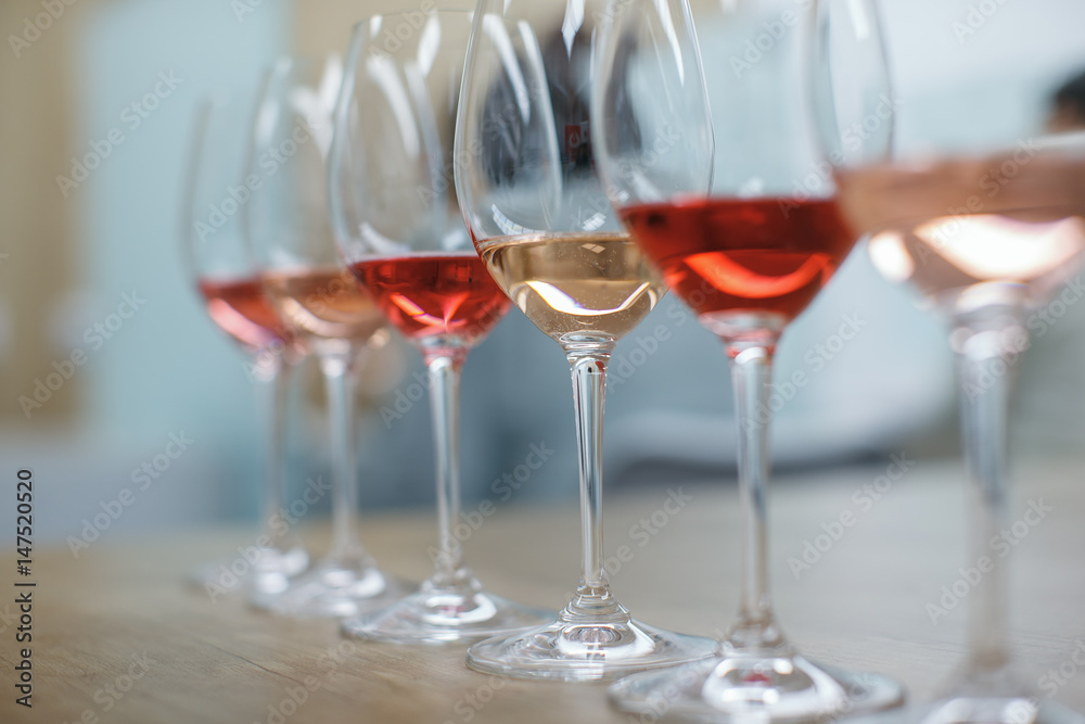 Row of glasses with white and rose wines prepared for tasting Row of glasses with white and rose wines prepared for tasting