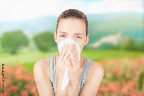 Donna con allergia si soffia il naso photo
