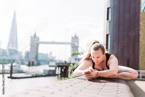 Woman in yoga position in fron of Tower Bridge, London
