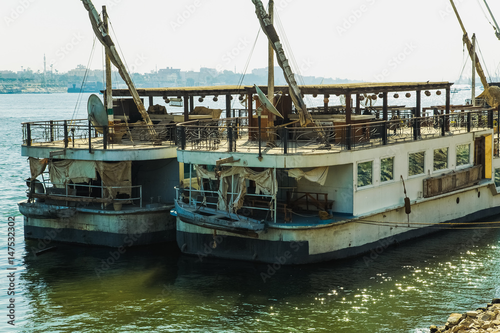 Old rusty and dirty yachts in harbor on Nile in Egypt.  Horizontal color photo.