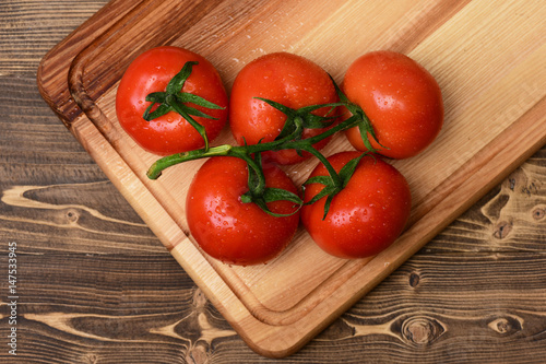 tomatoes on vine. Market vegetable concept. brown vintage wooden background