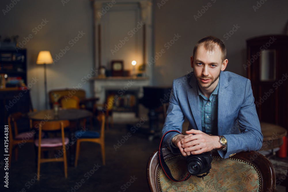 Young man photographer. Portrait in the interior