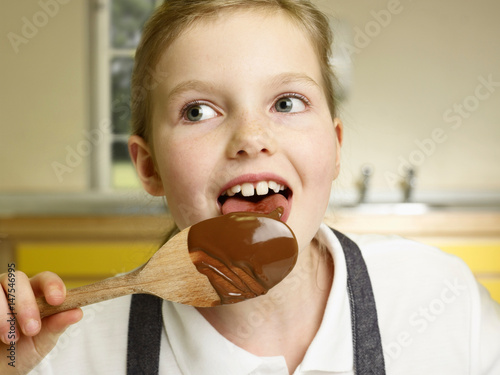 A girl licks a spoon photo