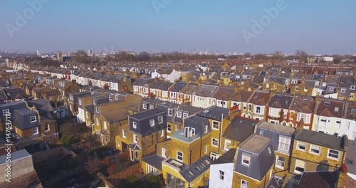 Flying above London surburban houses and apartments aerial view at dawn on sunny day