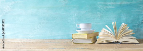 opened book, cup of coffee on grungy background, panoramic, copy space