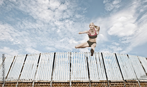 Athlete jumping over fence