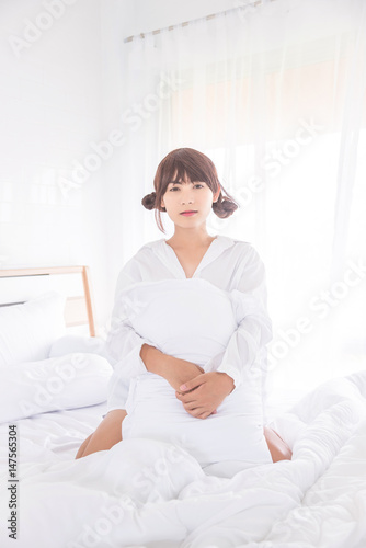 Beautiful asian boy sitting on bed