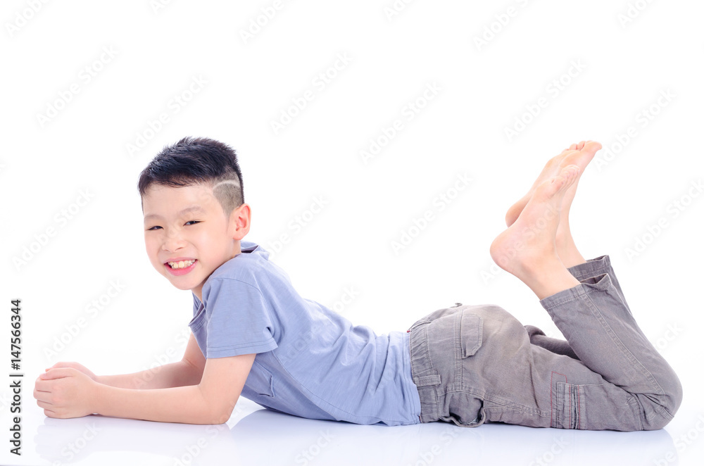 Young asian boy lying down on the floor over white