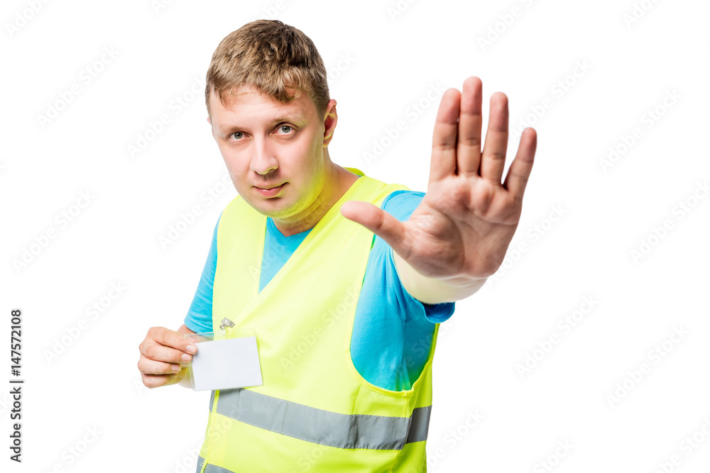 Worker in yellow waistcoat shows gesture with hand gesture STOP on white background