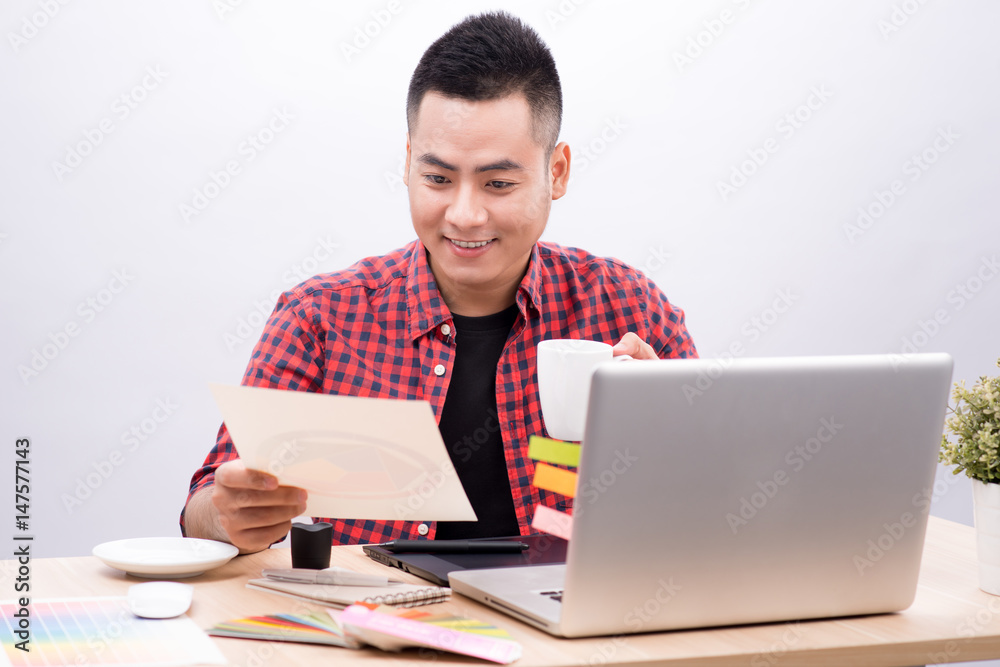 Happy designer working on his laptop in creative office Happy designer working on his laptop in creative office