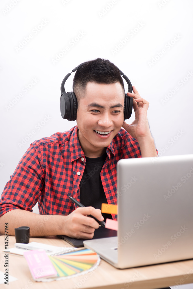 Happy designer working on his laptop in creative office Happy designer working on his laptop in creative office