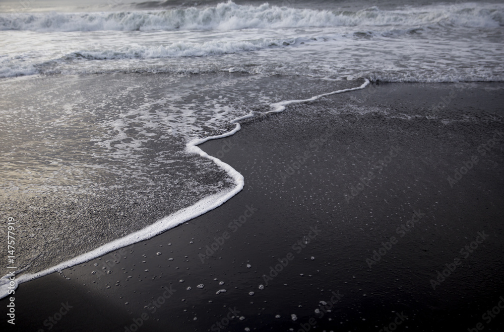 Fototapeta premium Black sand beach on the sunrise with white Indian ocean. Nobody in the beach. Paradise