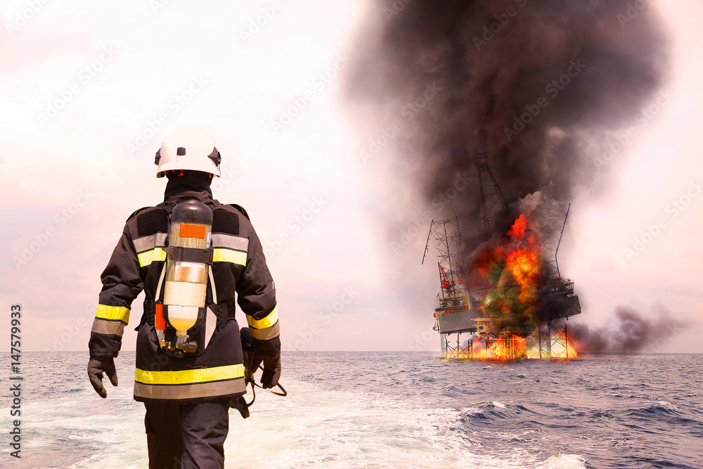 Obraz premium Firefighter in oil and gas industry with mission successful for protect with emergency case or worst case, Personal protective equipment of firefighter team and teamwork for danger mission.