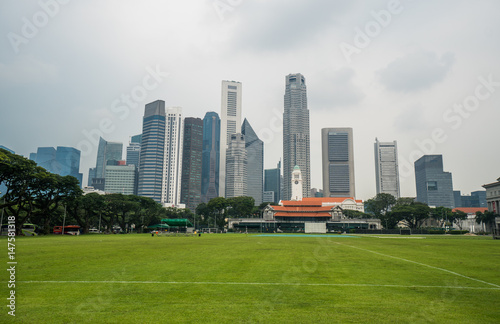 Singapore cityscape with football ground and high commercial buildings during cloudy day