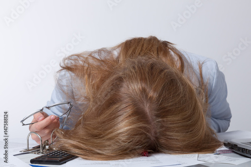 Junge Frau liegt erschöpft auf ihren Unterlagen photo