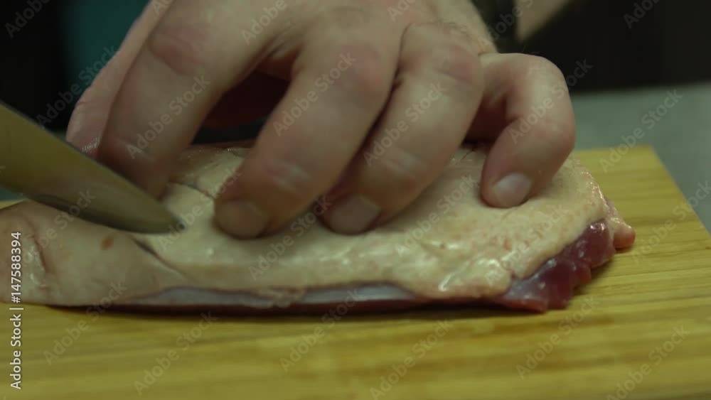 Chef cuts chicken breast for frying Chef cuts chicken breast for frying
