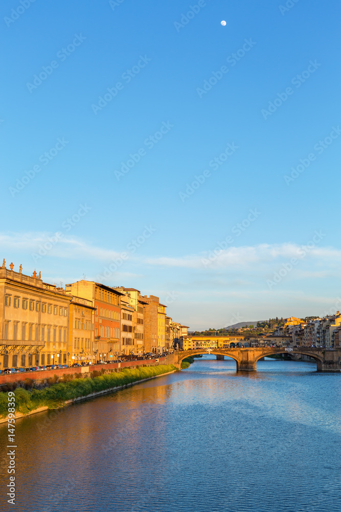 Arno River in Florence in the evening light and the full moon in the sky